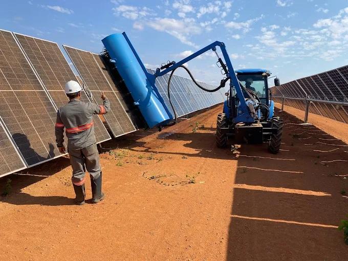 Trator trabalhando em fazenda de painéis solares